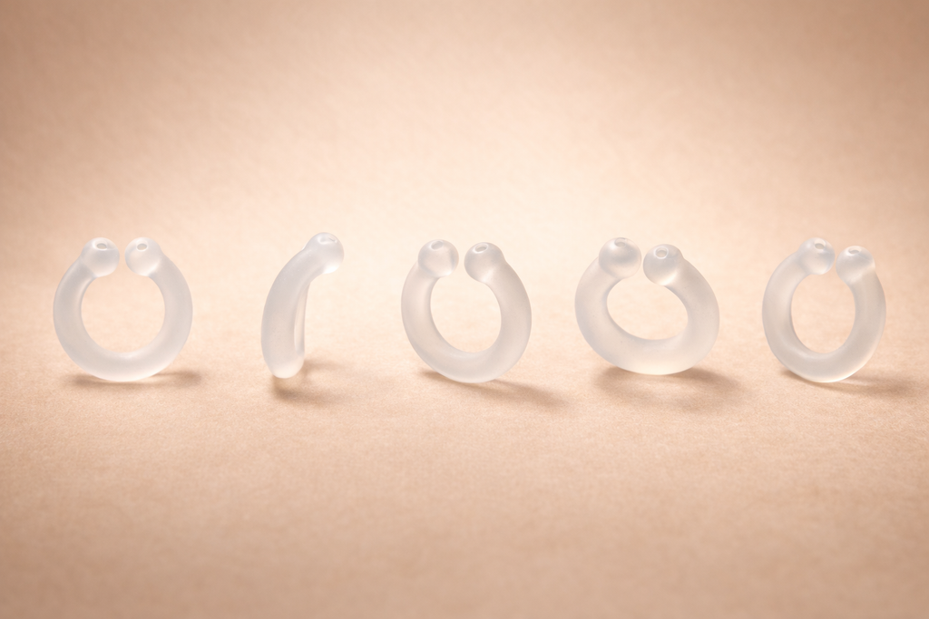 Auralis clear silicone wearable nasal aromatherapy ring shown from multiple angles on beige background