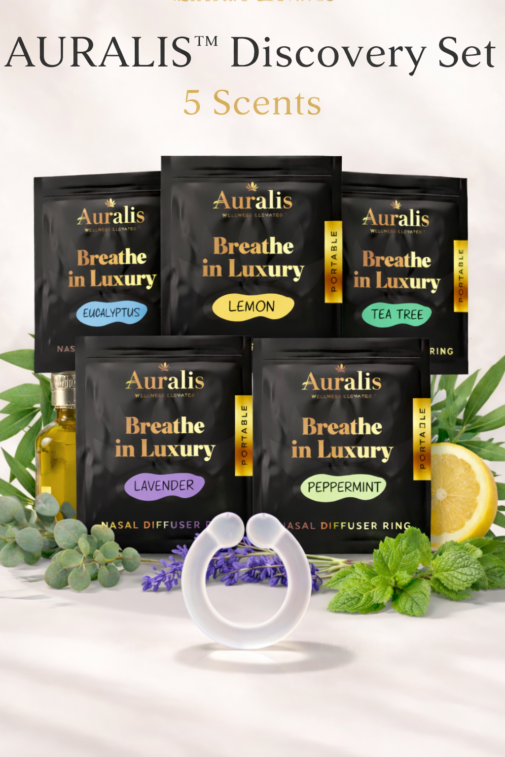 Auralis Discovery Set wearable nasal diffuser ring with five essential oil pouches — lemon, eucalyptus, lavender, peppermint, and tea tree — displayed on a white background with botanical accents and soft silicone ring