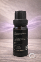 Back of Auralis essential oil bottle showing label details and usage instructions on gray background