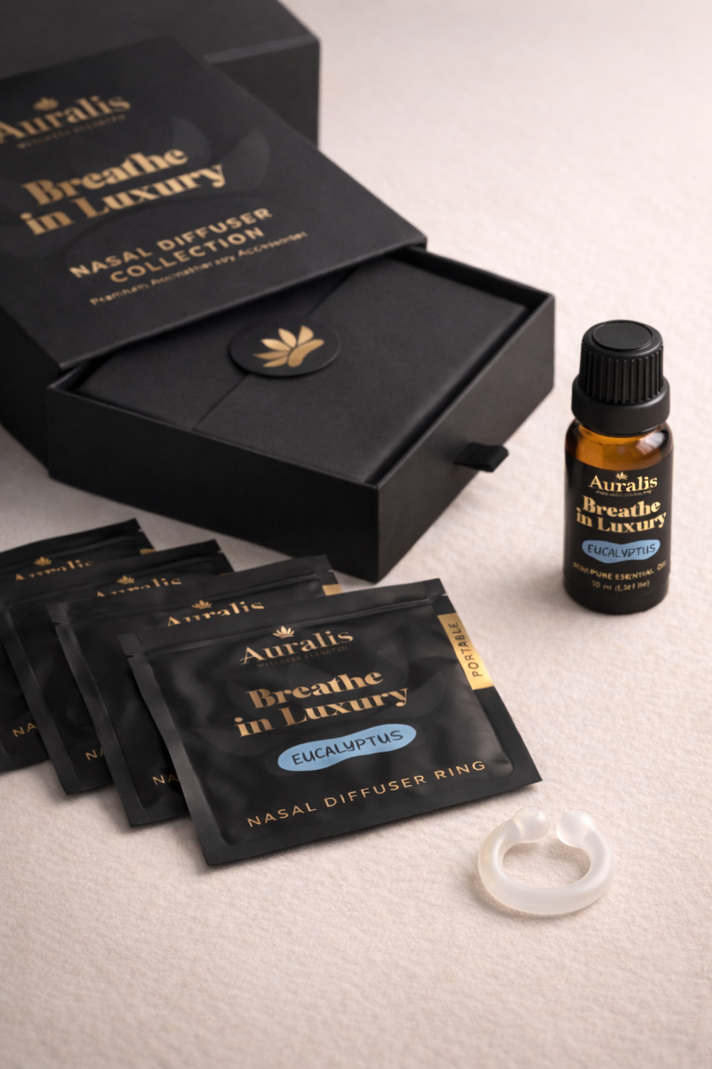Auralis Signature Set in Eucalyptus featuring essential oil bottle, five scented pouches, clear silicone wearable nasal aromatherapy ring, and packaging box